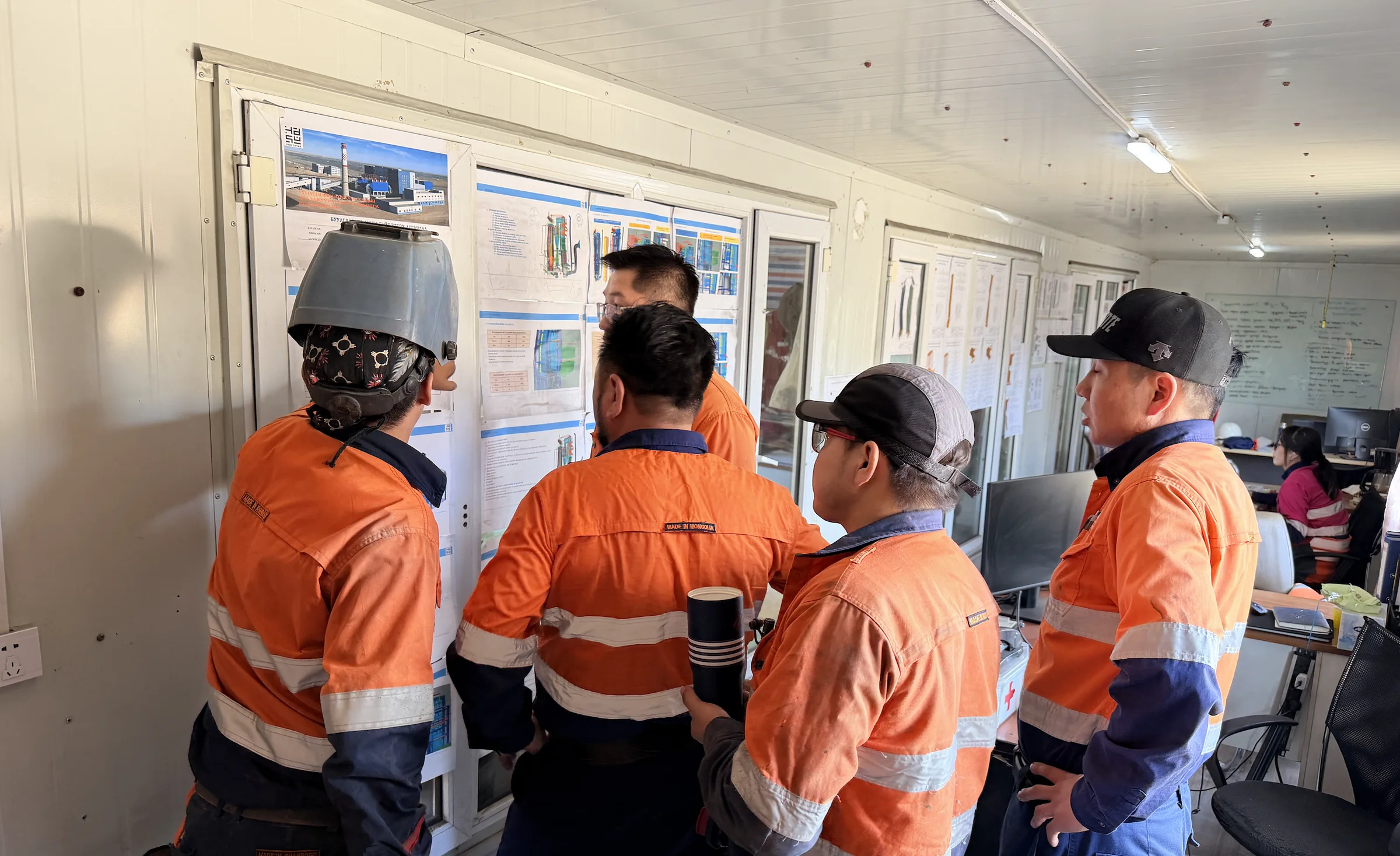 Hasu Dayan boiler overhaul team reviewing technical drawings at Ukhaa Khudag Power Plant